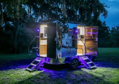 Dreamy Night Photo of Shiny Silver Restroom with Doors Open on Both Stalls